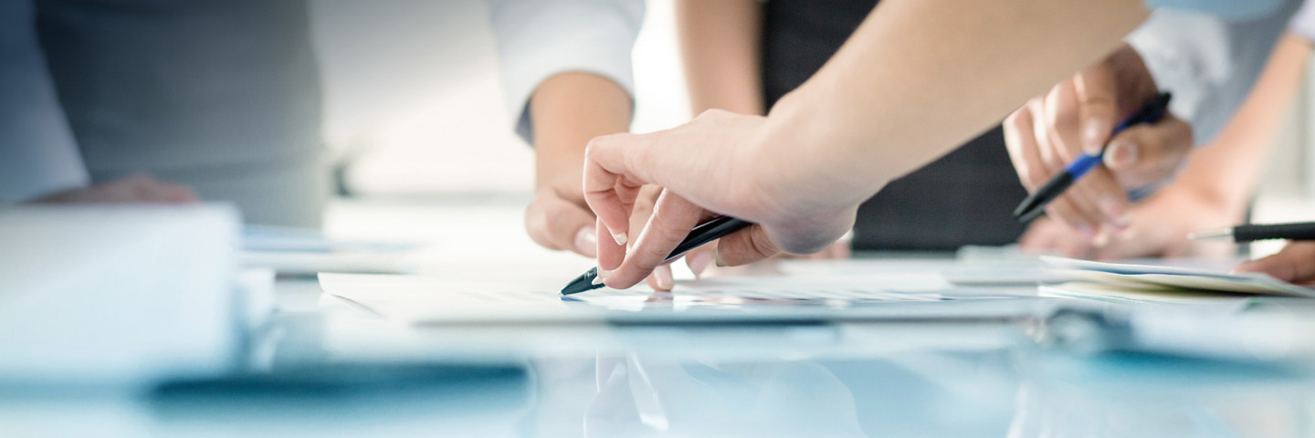 Image of hands pointing with pens