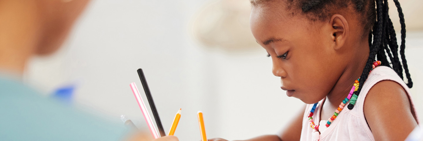 Image of little girl drawing with pencils