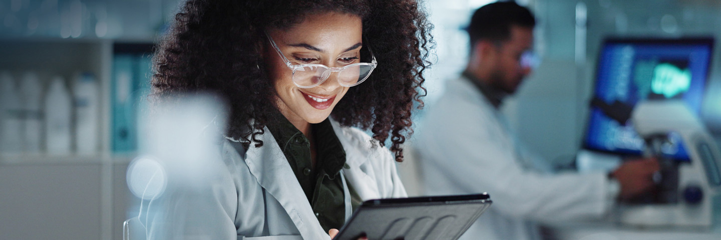 Woman in lab coat looking at tablet